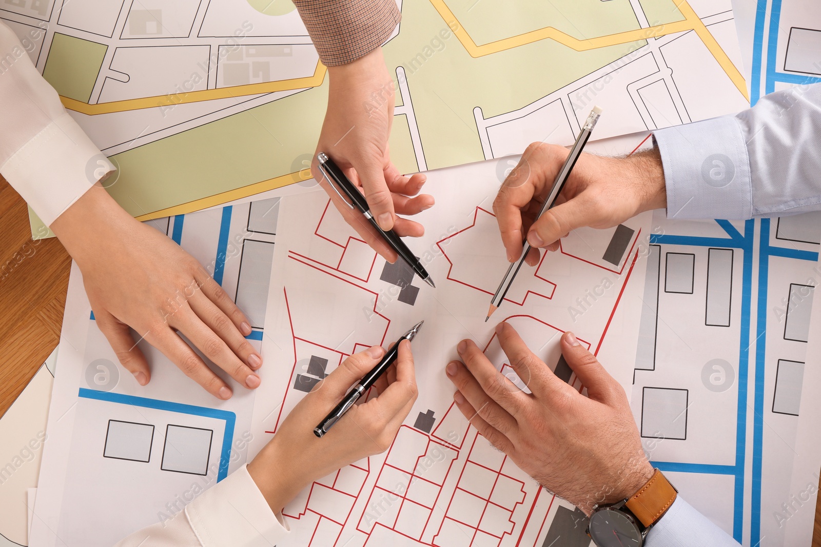 Photo of Professional cartographers working with cadastral map at table, top view