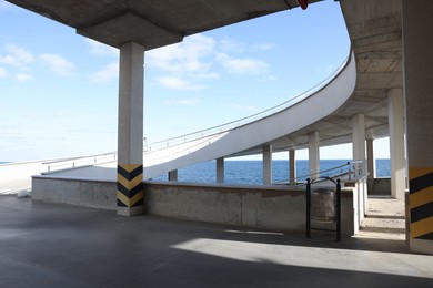 Photo of Open car parking with ramp near sea on sunny day