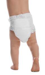 Photo of Cute baby in dry soft diaper standing isolated on white, closeup