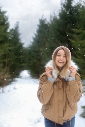 Photo of Young woman in snowy conifer forest. Winter vacation