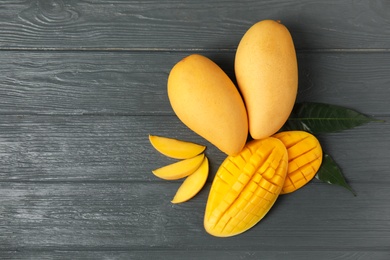 Photo of Flat lay composition with mango on wooden background. Space for text