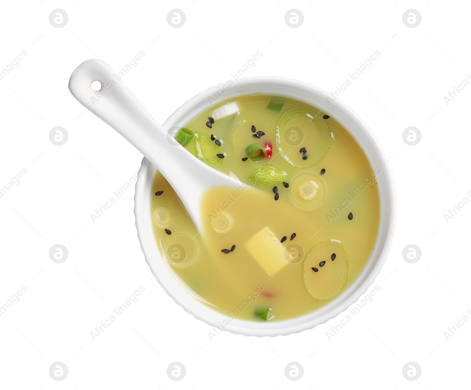 Photo of Bowl of delicious miso soup with tofu and spoon isolated on white, top view