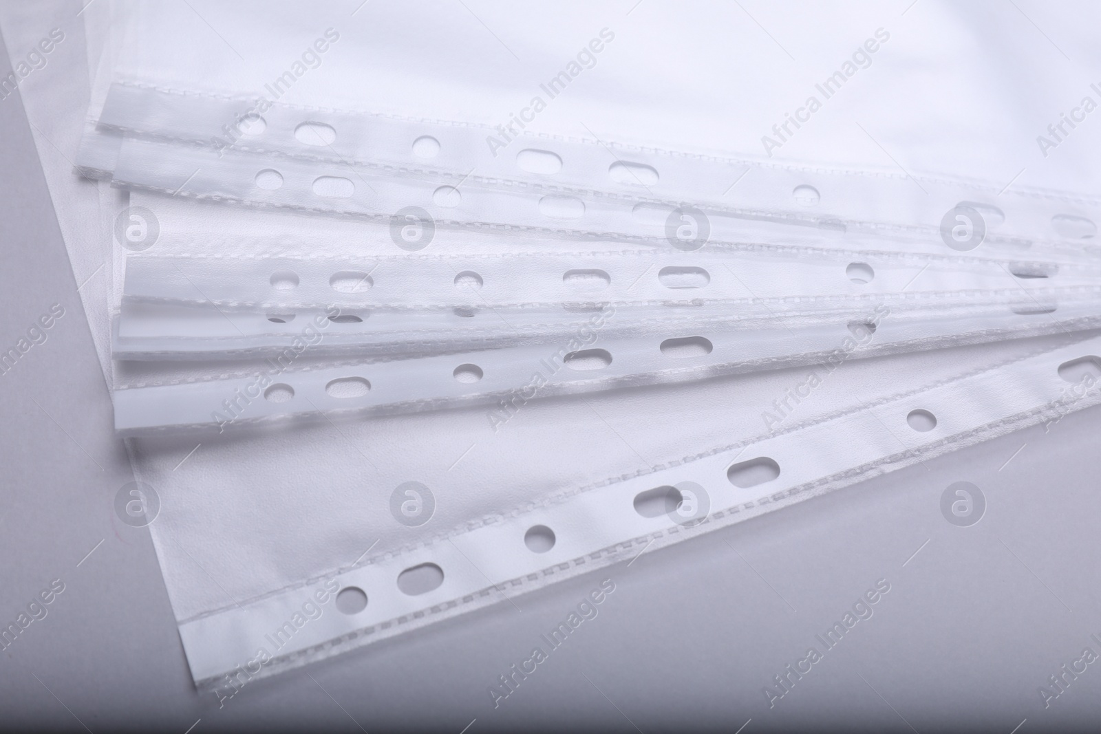 Photo of Many punched pockets on light grey background, closeup