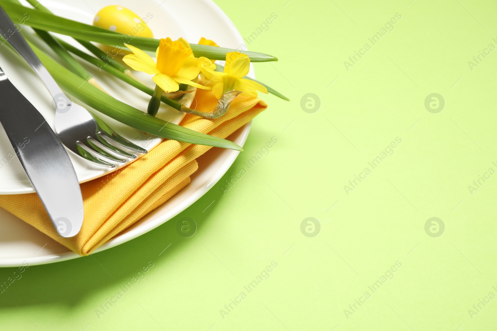 Photo of Festive Easter table setting with beautiful narcissuses, closeup. Space for text