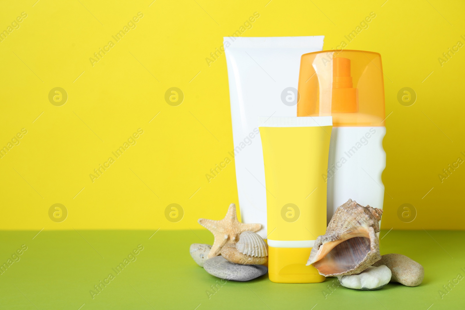 Photo of Different suntan products, seashells and starfish on color background. Space for text