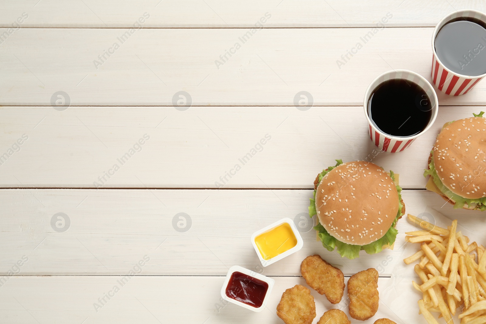 Photo of Flat lay composition with delicious fast food menu on white wooden table. Space for text