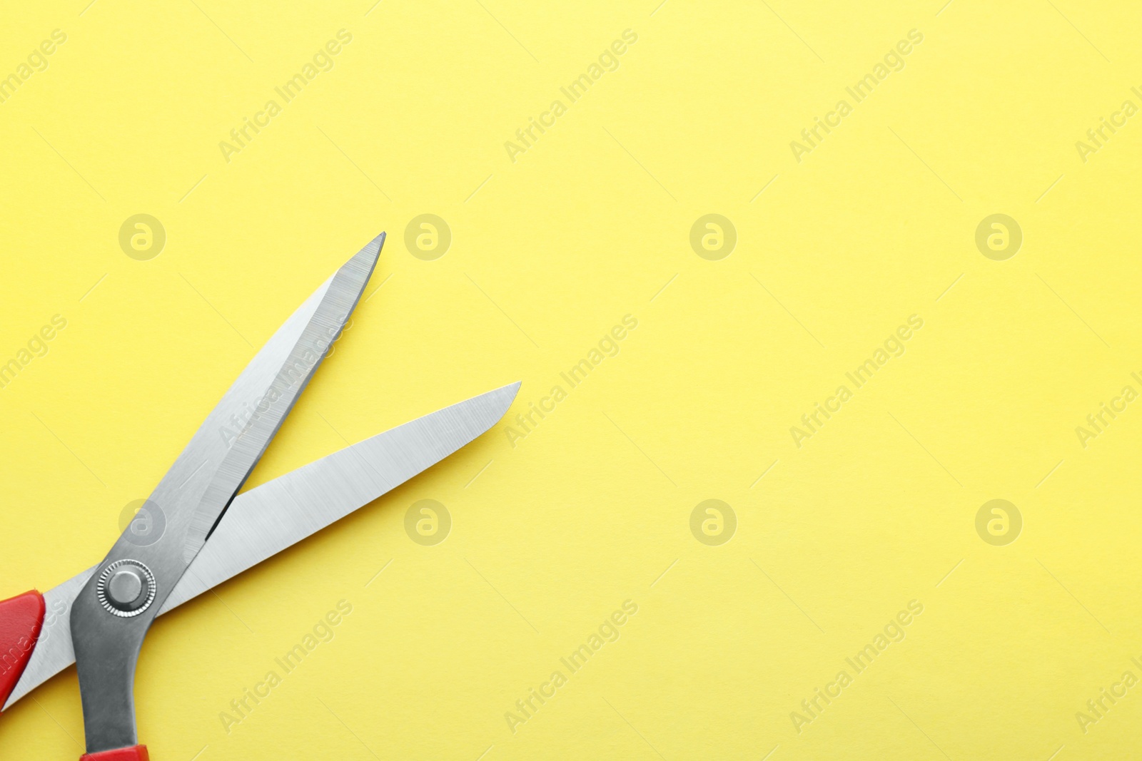 Photo of Pair of sharp scissors on color background, top view. Space for text