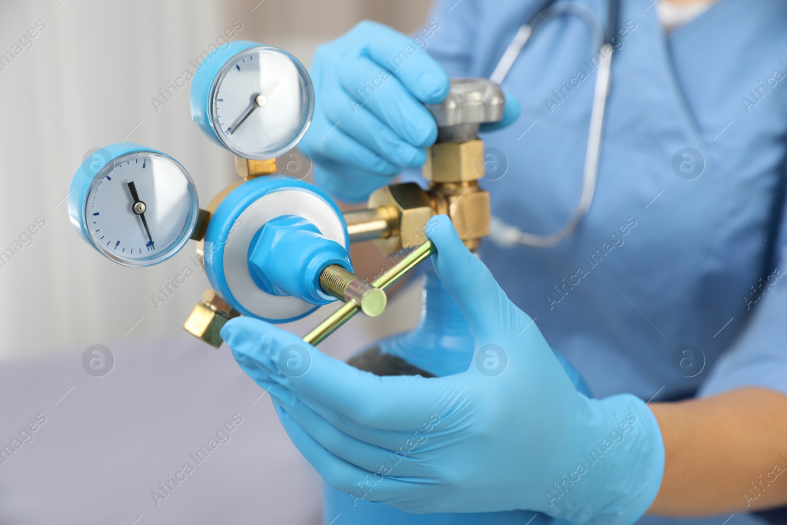 Photo of Medical worker checking oxygen tank in hospital room, closeup