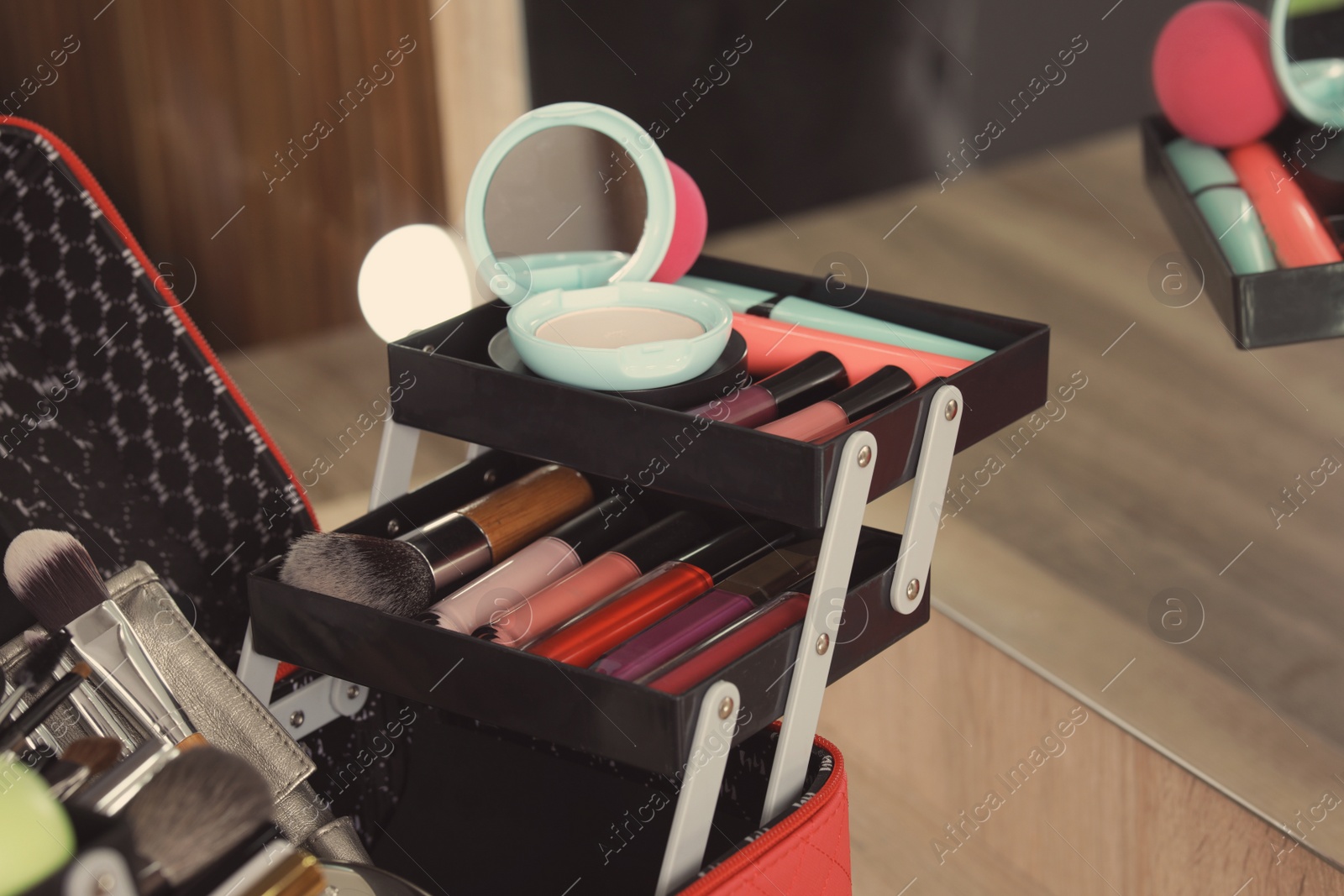 Photo of Beautician case with professional makeup products and tools on dressing table