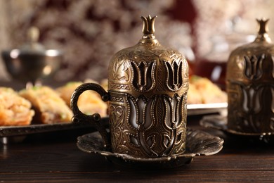 Photo of Traditional Turkish tea and fresh baklava served in vintage tea set on wooden table