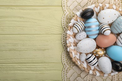 Photo of Many beautifully decorated Easter eggs on yellow wooden table, top view. Space for text