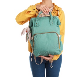 Woman holding maternity backpack with baby accessories on white background, closeup