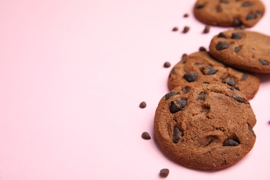 Photo of Delicious chocolate chip cookies on color background. Space for text