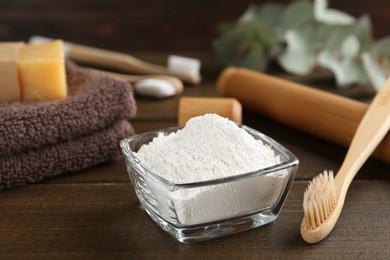 Photo of Tooth powder and brush on wooden table, closeup