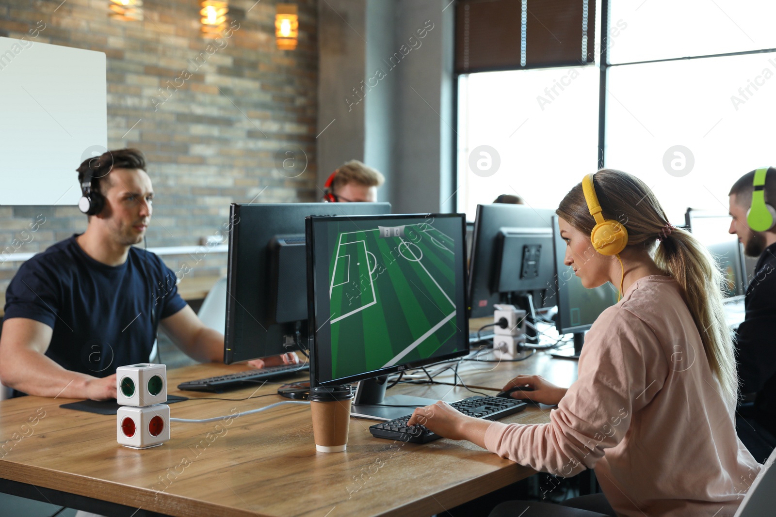 Photo of Group of people playing video games in internet cafe