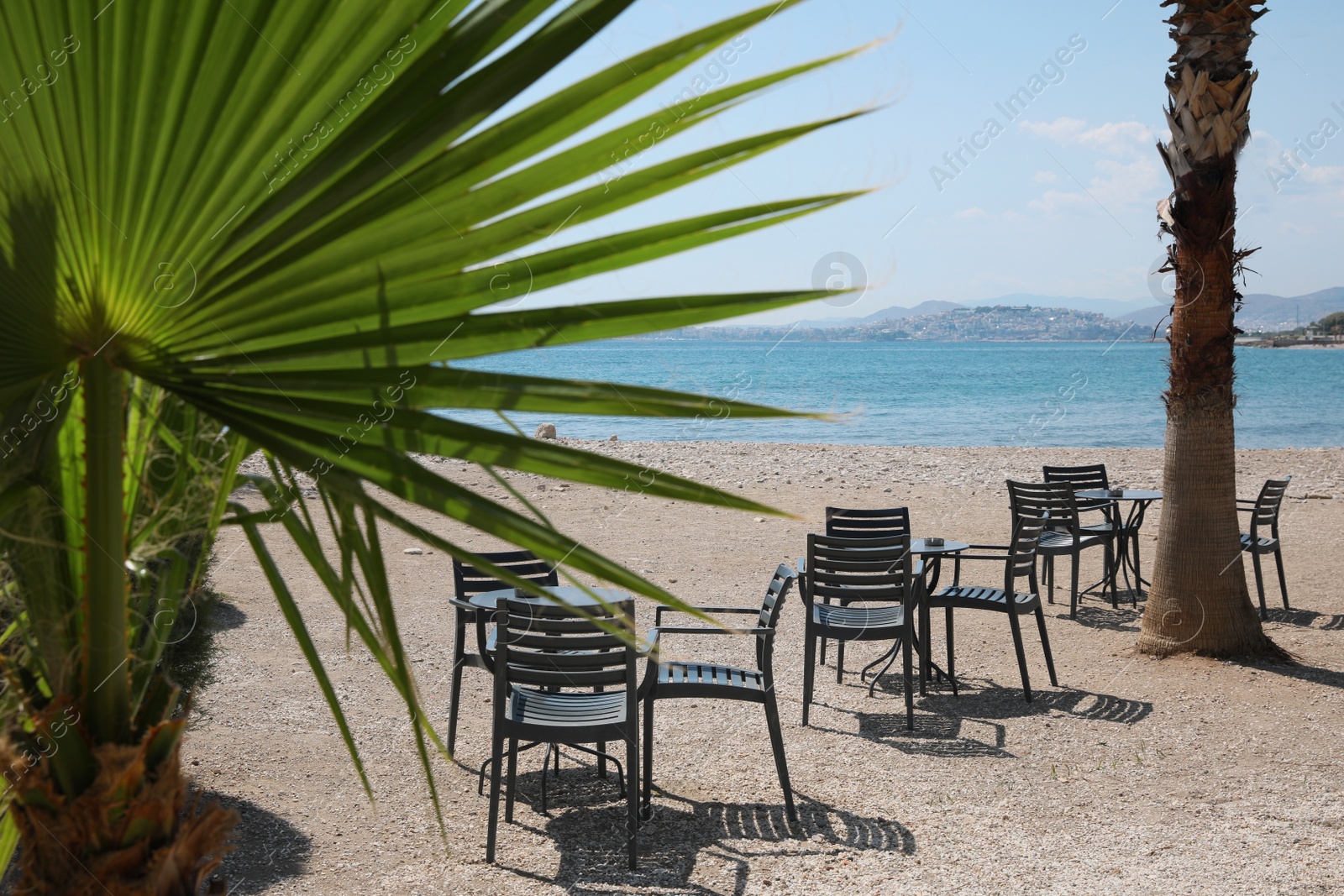 Photo of Beautiful view of chairs and tables on sandy beach near sea