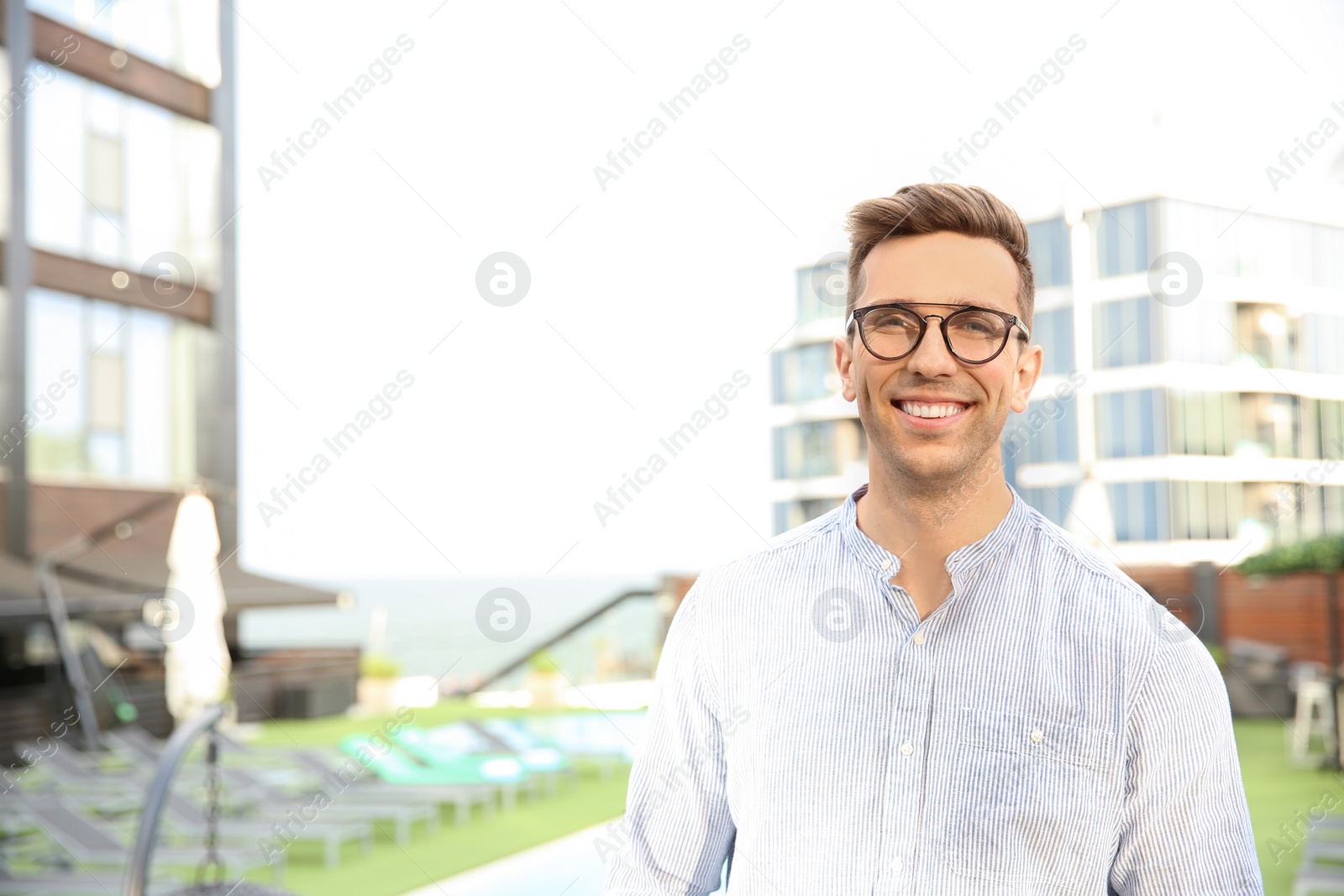 Photo of Portrait of attractive young man in stylish outfit outdoors