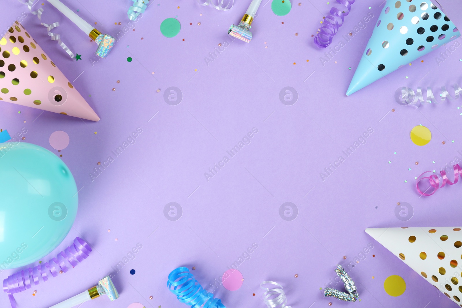 Photo of Frame of colorful serpentine streamers and other party accessories on violet background, flat lay. Space for text