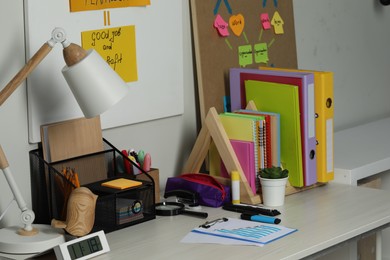 Photo of Business process planning and optimization. Workplace with lamp, colorful paper notes and other stationery on wooden table