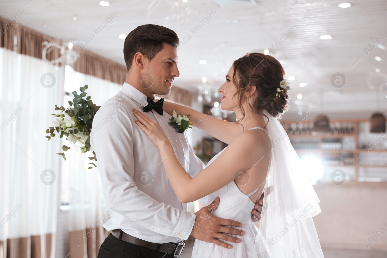 Photo of Happy newlywed couple dancing together in festive hall