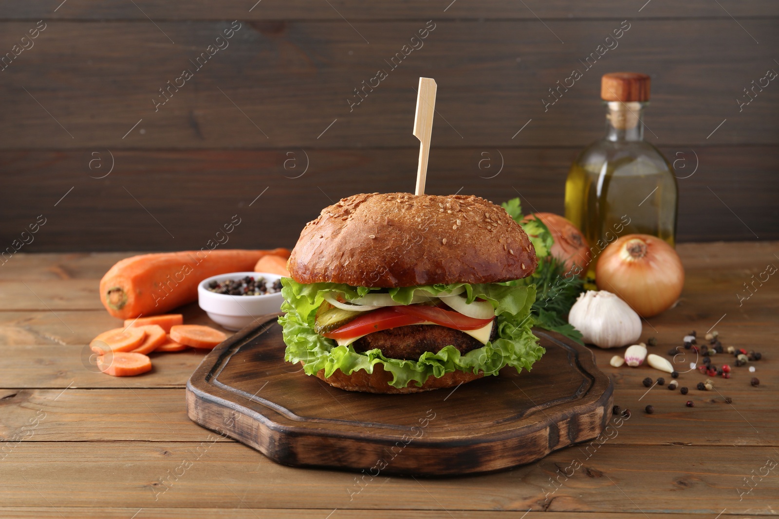 Photo of Delicious vegetarian burger and ingredients on wooden table