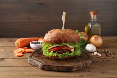 Delicious vegetarian burger and ingredients on wooden table