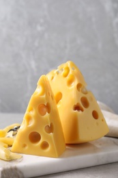 Tasty fresh cheese on white marble board, closeup
