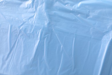 Photo of Texture of light blue plastic bag as background, closeup