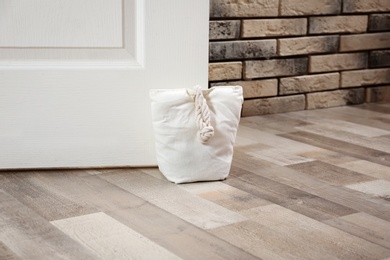 Photo of Stuffed bag holding wooden door at home