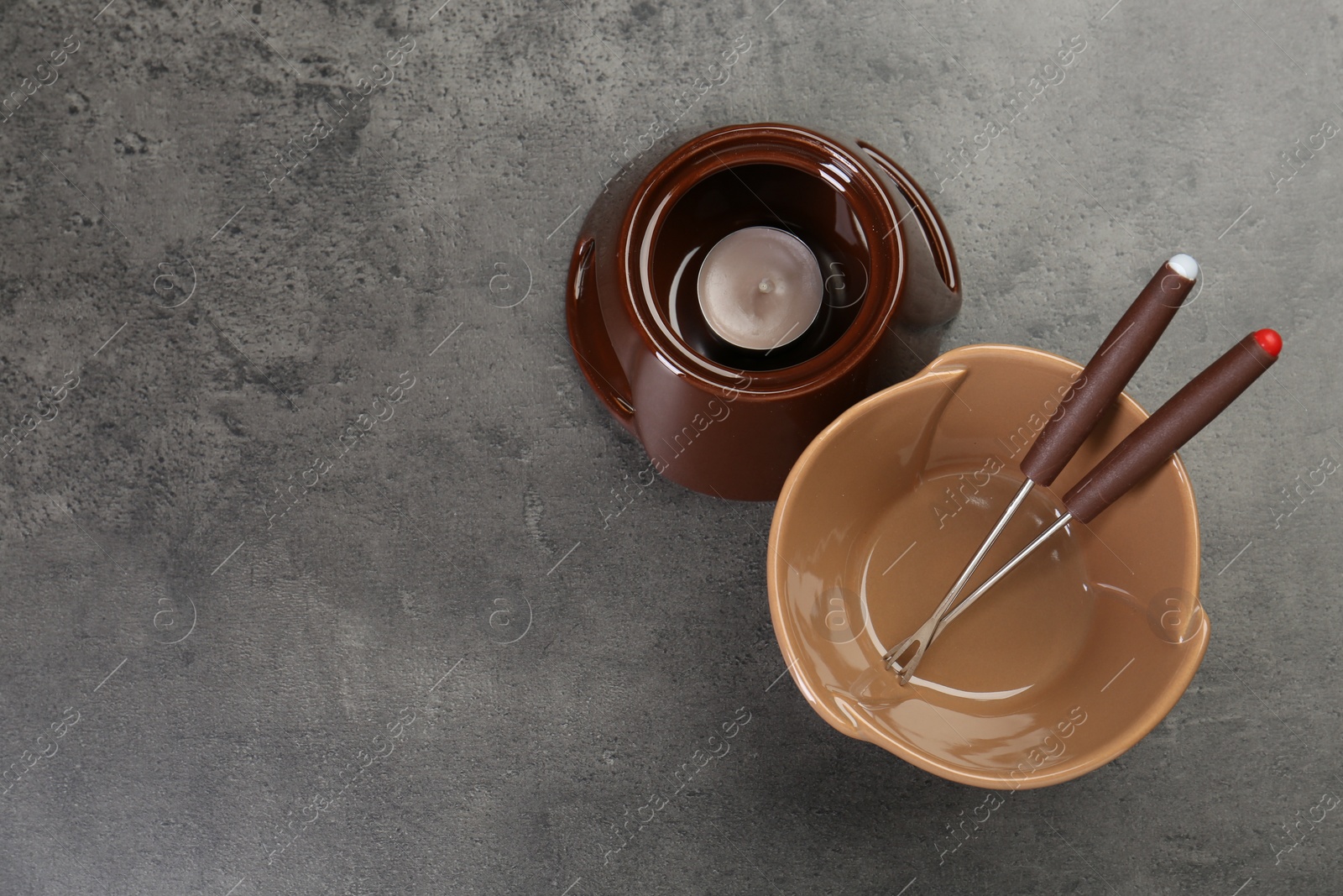 Photo of Fondue set on grey textured table, flat lay. Space for text