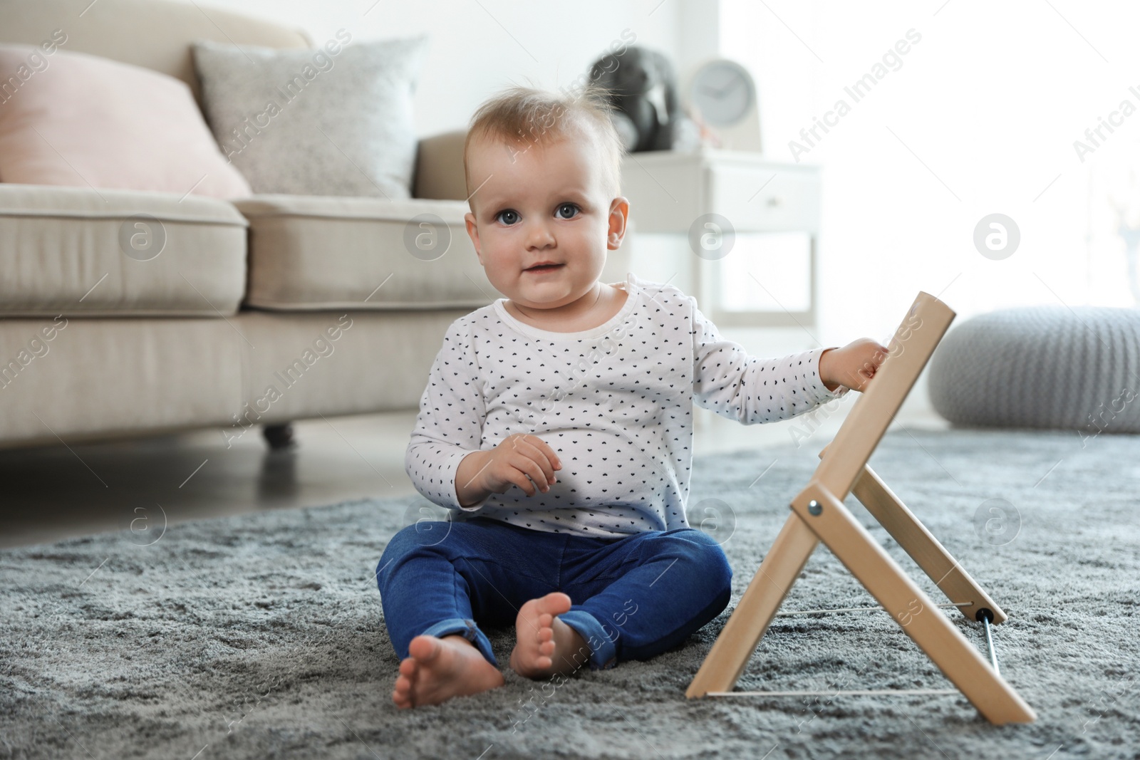 Photo of Cute baby playing with abacus on floor in room