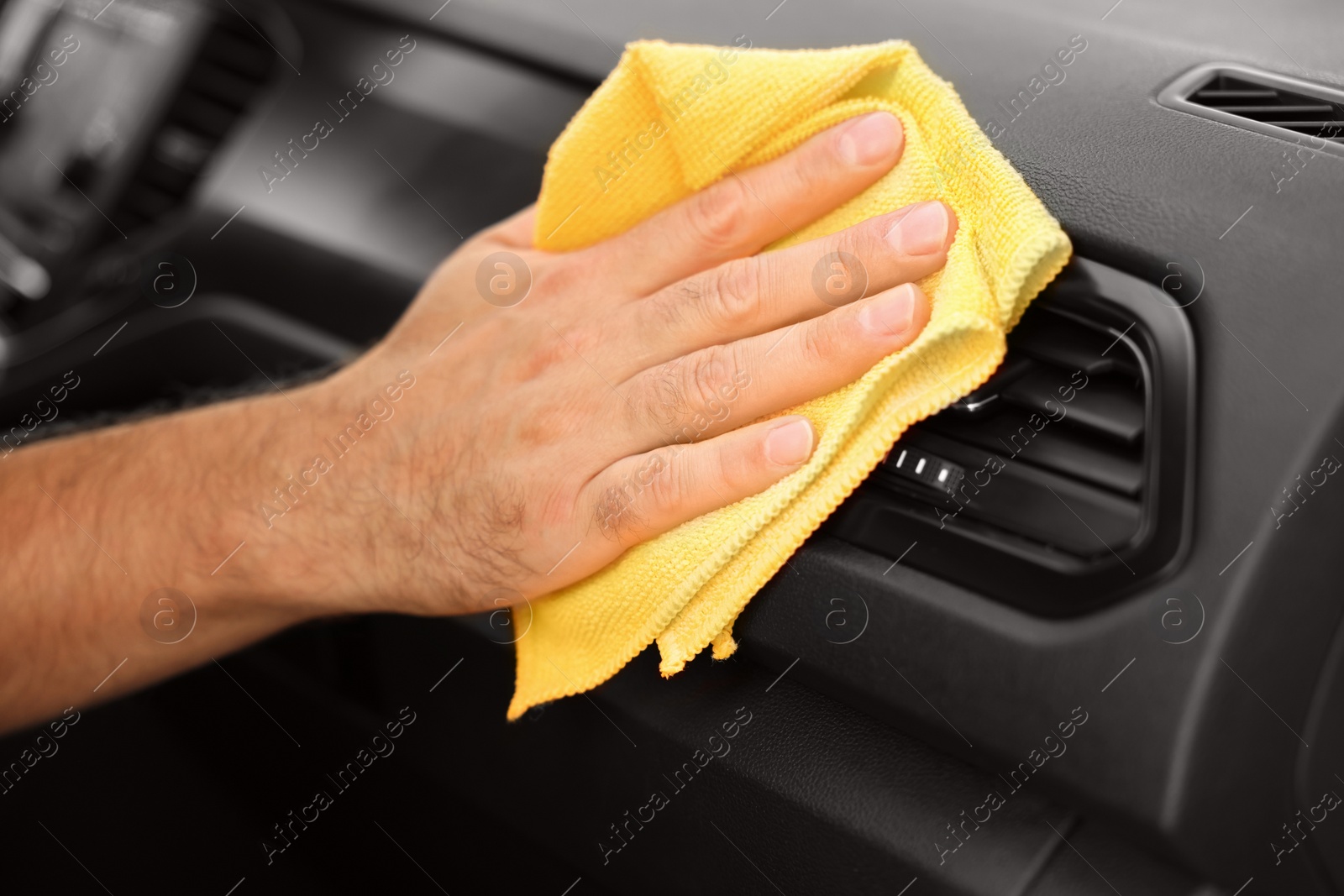 Photo of Man cleaning car interior with rag, closeup