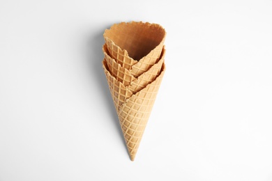 Photo of Empty wafer ice cream cones on white background, top view