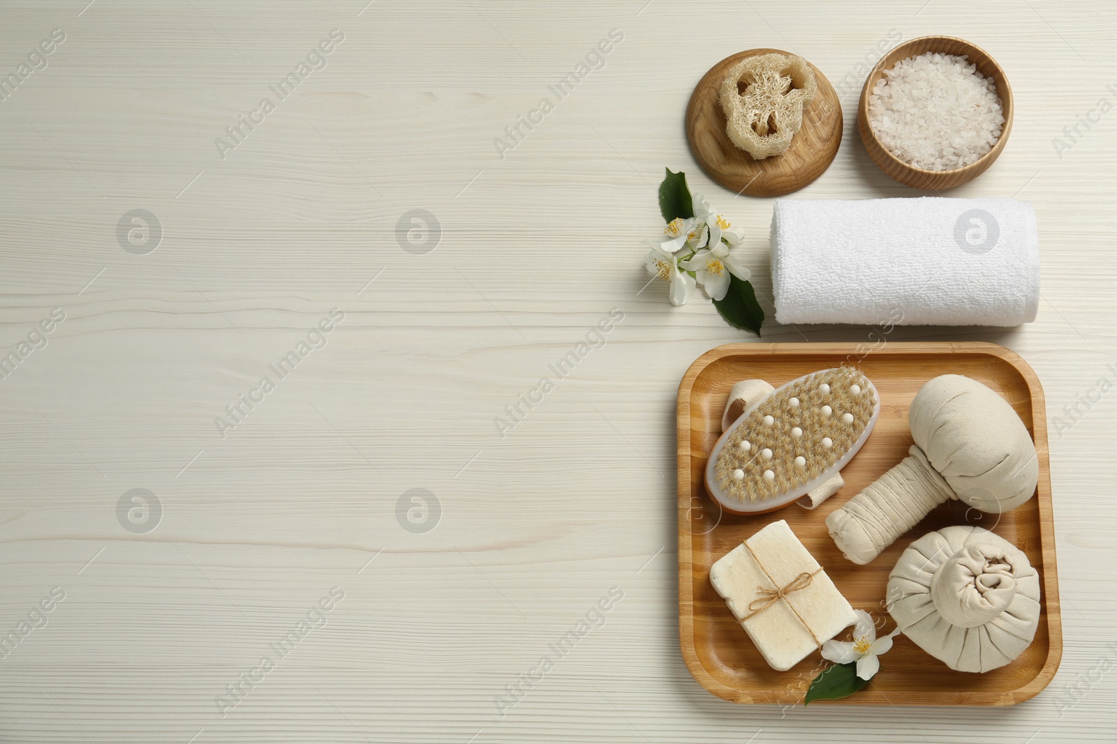 Photo of Flat lay composition with beautiful jasmine flowers and herbal bags on white wooden table, space for text