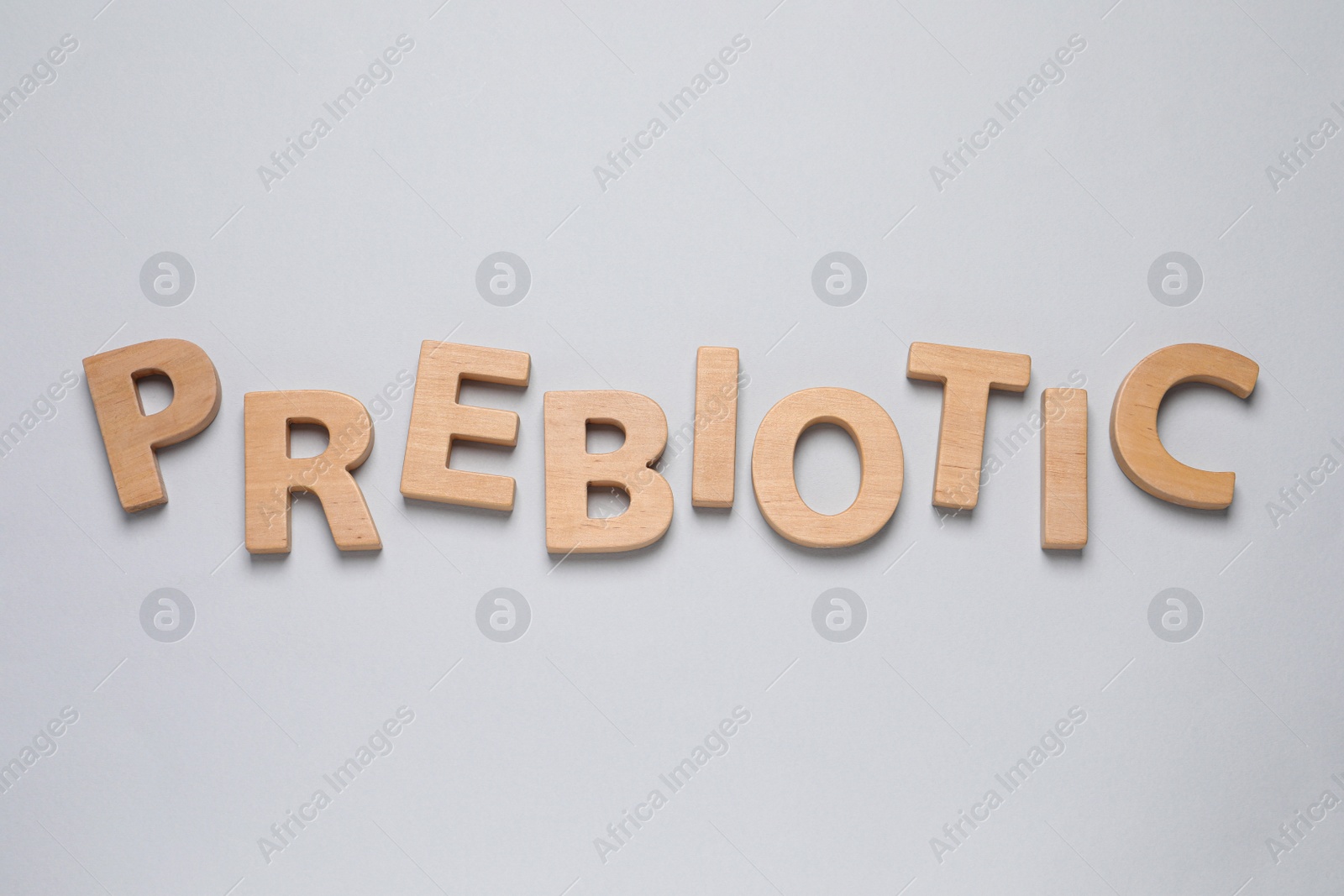 Photo of Word Prebiotic made of wooden letters on white background, top view