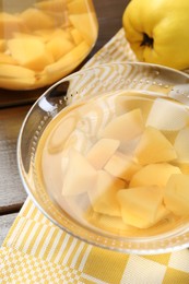 Delicious quince drink in glass bowl and fresh fruit on wooden table, closeup