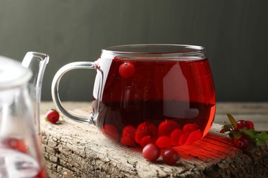 Photo of Delicious cranberry tea and berries on wooden table, closeup