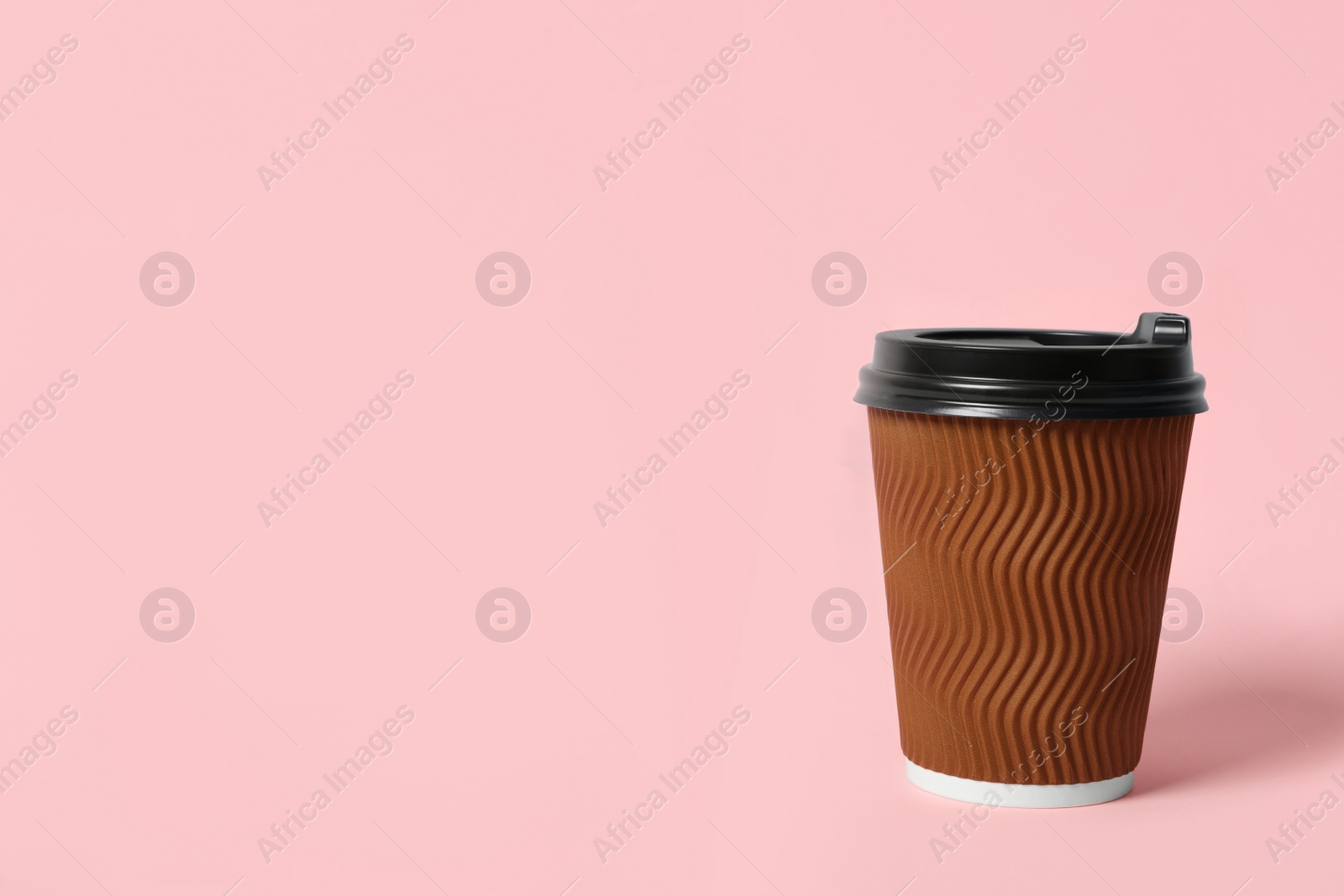 Photo of Takeaway paper coffee cup on pink background. Space for text