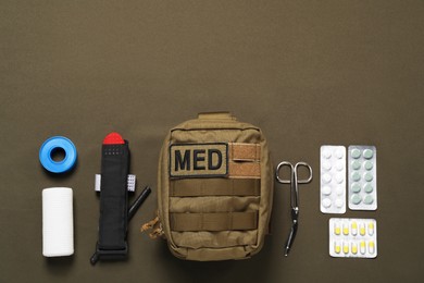Photo of Flat lay composition with military first aid kit on khaki background. Space for text