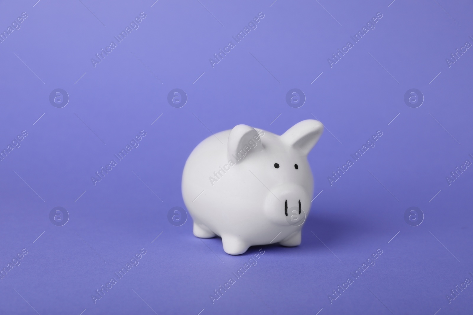 Photo of Ceramic piggy bank on purple background. Financial savings