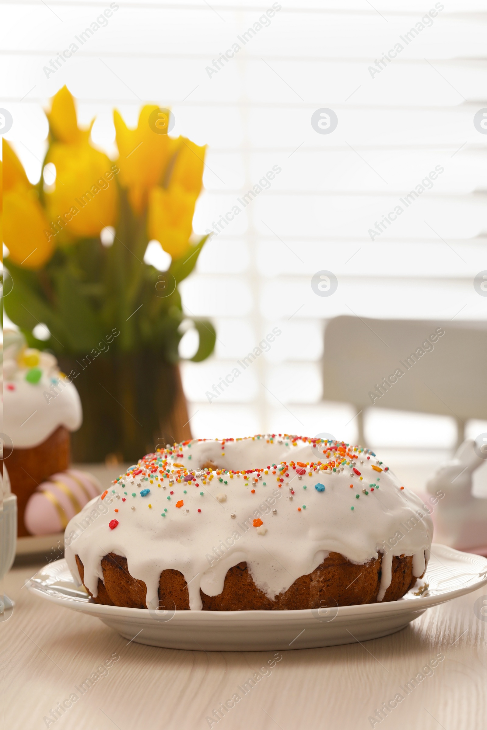 Photo of Delicious Easter cake decorated with sprinkles on white wooden table