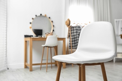 Photo of Stylish white chair in makeup room interior. Space for text