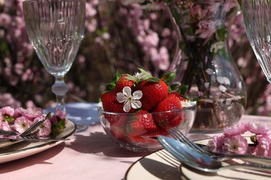 Photo of Stylish table setting with beautiful spring flowers in garden, closeup