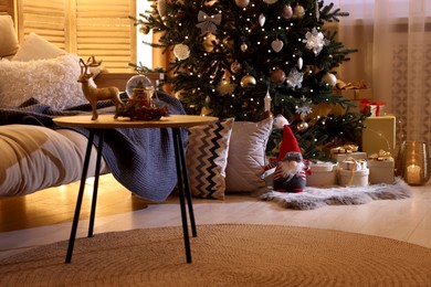 Beautiful Christmas tree and gift boxes in festively decorated room