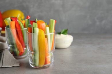 Photo of Different vegetables cut in sticks on light grey table. Space for text