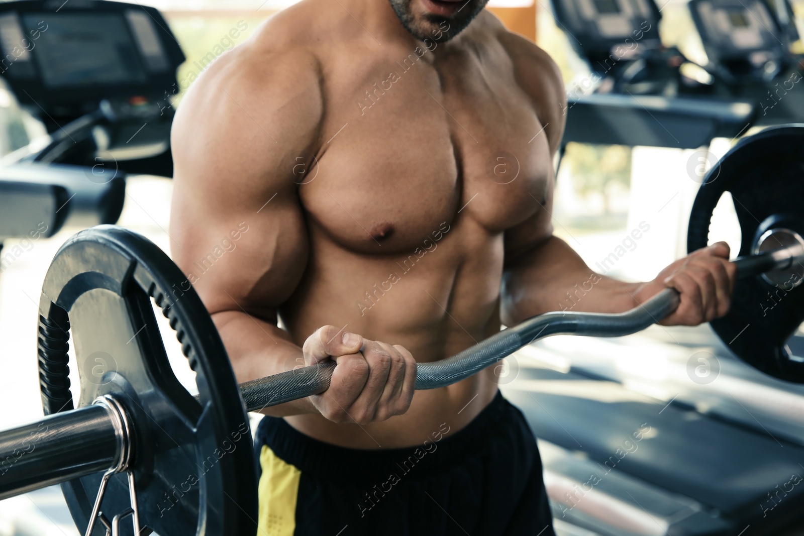 Photo of Strong young man lifting barbell in gym