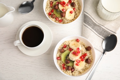 Photo of Flat lay composition with quinoa porridge and coffee on wooden background. Tasty breakfast