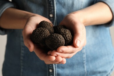 Woman holding heap of black truffles in hands, closeup