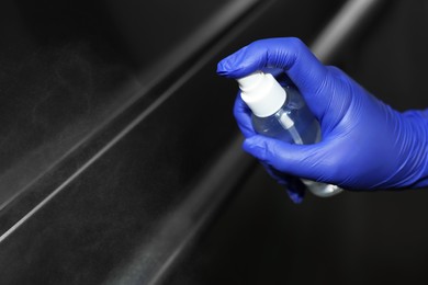 Photo of Woman cleaning elevator`s handrails with detergent, closeup