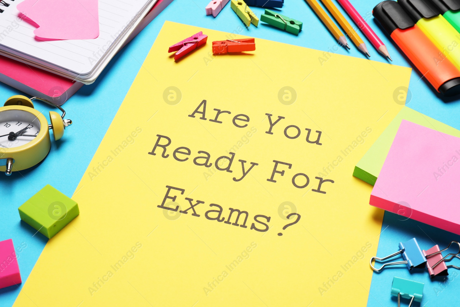 Photo of Yellow paper with question Are you ready for exams and stationery on light blue table, closeup